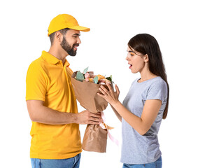 Young woman receiving bouquet of flowers from delivery man on white background