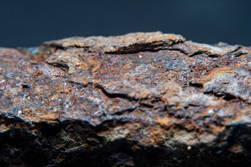 Close-up of part of rusty metal crutch in soft focus against dark background