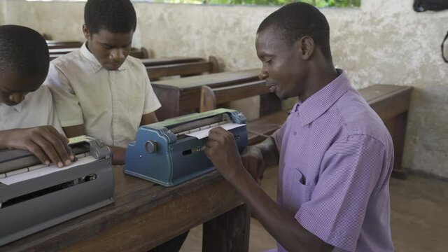 Teacher working with blind and partially sighted students. Africa
