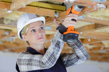 female worker drilling a wood structure