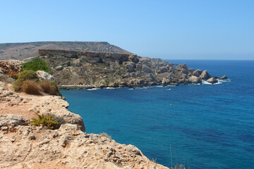 Fototapeta na wymiar Golden bay beach on Malta island with beautiful blue sea water and rocky coastline in bright sunny day