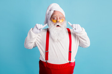 Fototapeta na wymiar Photo of retired old man grey beard direct finger face excited look unexpected effect patch under eye wear santa x-mas costume towel turban suspender sunglass isolated blue color background