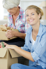 senior woman and daughter holding cardboard boxes