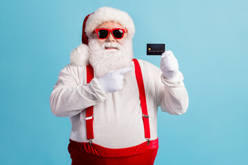 Fototapeta na wymiar Portrait of attractive cheerful confident white-haired Santa hold in hand demonstrating credit card shopping service finance advert loan cash isolated bright vivid shine vibrant blue color background