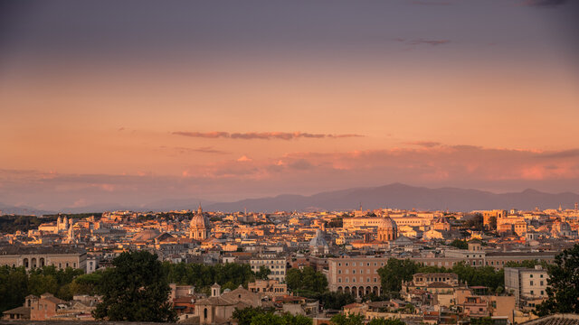Beautiful skyline view of Roma from the Gianicolo hill at the sunset. Panorama of Rome from the above Colorful sky with orange clouds over the ancient monuments of the Italian Capital. Europe postcard