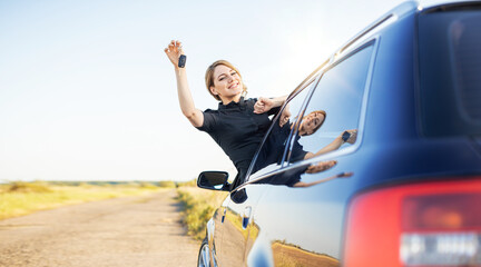 The woman driver shows the key to the car. Car purchase or rental.