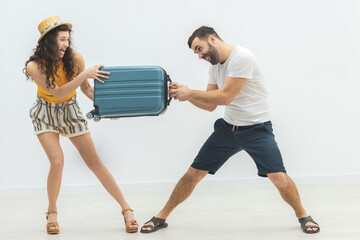 Photo where man and woman holding big suitcases for travelling.