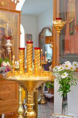 Interior of a Christian Orthodox Church in Russia. Candles, icons, and flowers. The religious concept.