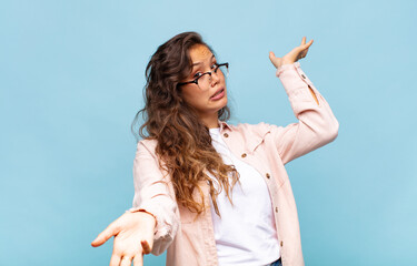  shrugging with a dumb, crazy, confused, puzzled expression, feeling annoyed and clueless