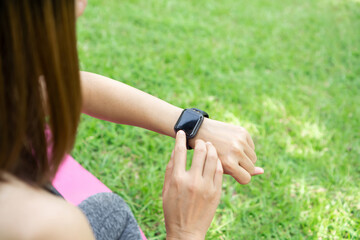 closeup woman arm wearing smart watch and setting the program while doing yoga 