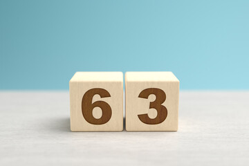Wooden toy blocks forming the number 63.
