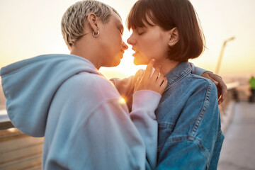 Young lesbian couple having romantic moment, Two women going to kiss while watching the sunrise together, Selective focus