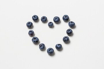 blueberries in a heart shape on white background, heartshaped fruit