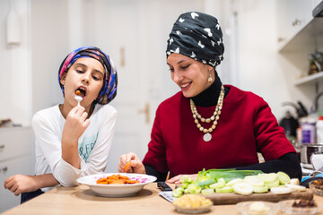 Healthy food at home. Happy family in the kitchen. Mother and child daughter are preparing the vegetables and fruit.