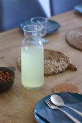 Bottle of homemade lemonade, served on a table. Selective focus.
