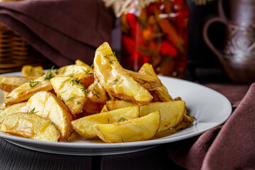 Country style potatoes with melted cheese. Serving food in a restaurant on a white plate. Background image.
