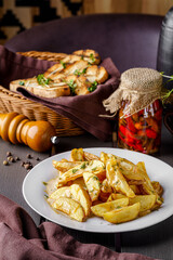Country style potatoes with melted cheese. Serving food in a restaurant on a white plate. Background image.