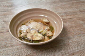 spicy slice pomfret or butter fish and straw mushroom in Tom Yum soup on bowl