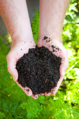 black soil in man hand