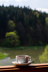 Cup of coffee on a wooden terrace