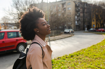 Young smiling african american girl walking through the city.