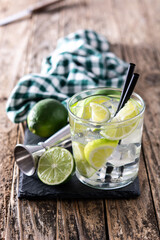Caipiroska cocktail with lime on wooden table