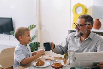 grandfather and grandson having breakfast at home
