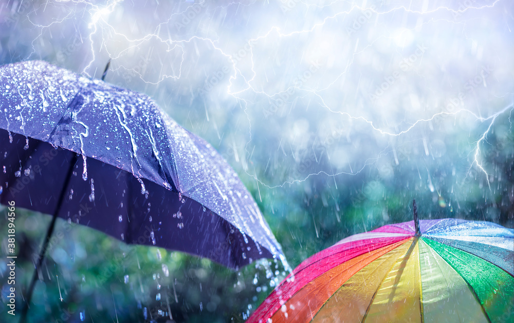Wall mural abstract weather concept - rain and lightning on umbrellas with defocused background
