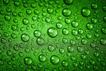 Green water drops on a glitter surface, abstract macro photography