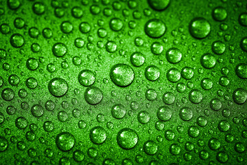 Fototapeta na wymiar Green water drops on a glitter surface, abstract macro photography