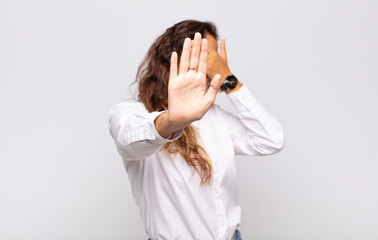  covering face with hand and putting other hand up front to stop camera, refusing photos or pictures