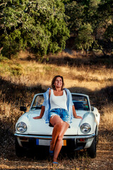 Fototapeta na wymiar Woman with white convertible vintage car