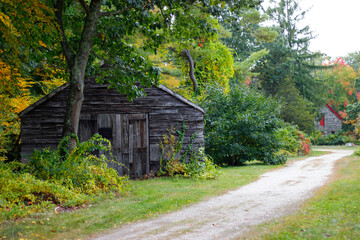 Fototapeta na wymiar Grass pathway to the mill with waterwheel and waterfall in beautiful autumn, Sudbury, Massachusetts
