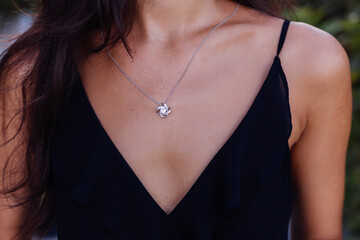 Outdoor portrait of woman in black dress with silver celtic knot necklace    