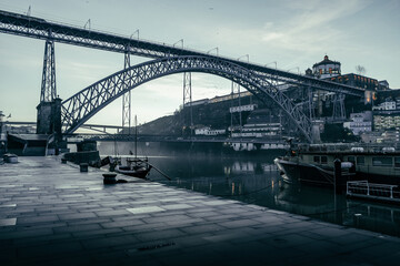 Fototapeta na wymiar View on Douro river and the Dom Luís I Bridge from seafront at misty early morning