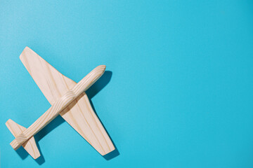 Wood airplane on blue background, top view
