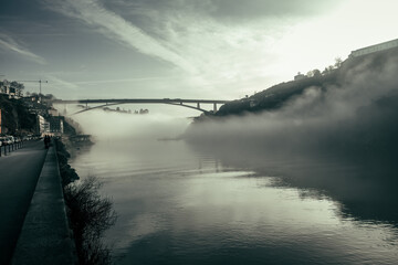 View on Douro river and the bridge from seafront at misty early morning