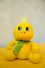 yellow duckling toy on a yellow background. Soft toy for a child.