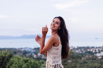 Portrait of happy caucasian calm  romantic woman in casual look with long hair wearing earings and necklace on background amazing beautiful view on green mountains  