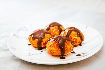 Profiterole with vanilla and chocolate sauce