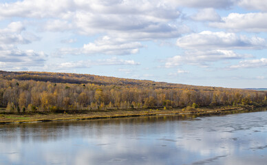 Beautiful, wide river autumn among the woods.