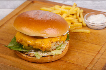 Homemade burger with fish, cheese and salad leaves