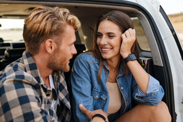 Smiling young couple sitting in car
