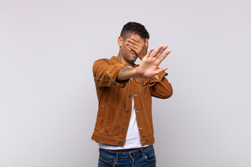  covering face with hand and putting other hand up front to stop camera, refusing photos or pictures