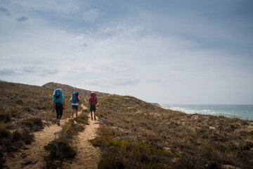 Hikers walking along dunes
