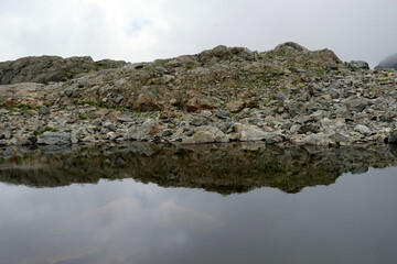 Alpine lake in a rocky valley. Valley in front of the Koshtan pass (3450 meters above sea level). Caucasus, Russia.