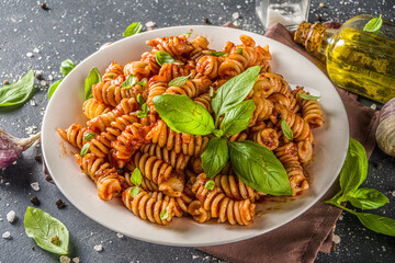 Fusilli pasta with tomato sauce and basil. Traditional italian Fusilli pasta marinara, on dark background copy space