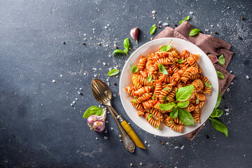 Fusilli pasta with tomato sauce and basil. Traditional italian Fusilli pasta marinara, on dark...
