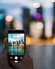 a person taking a photo of a cityscape using a phone