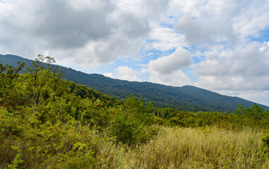 Fototapeta na wymiar Beautiful mountain range in summer against a blue sky with clouds. blurry focus
